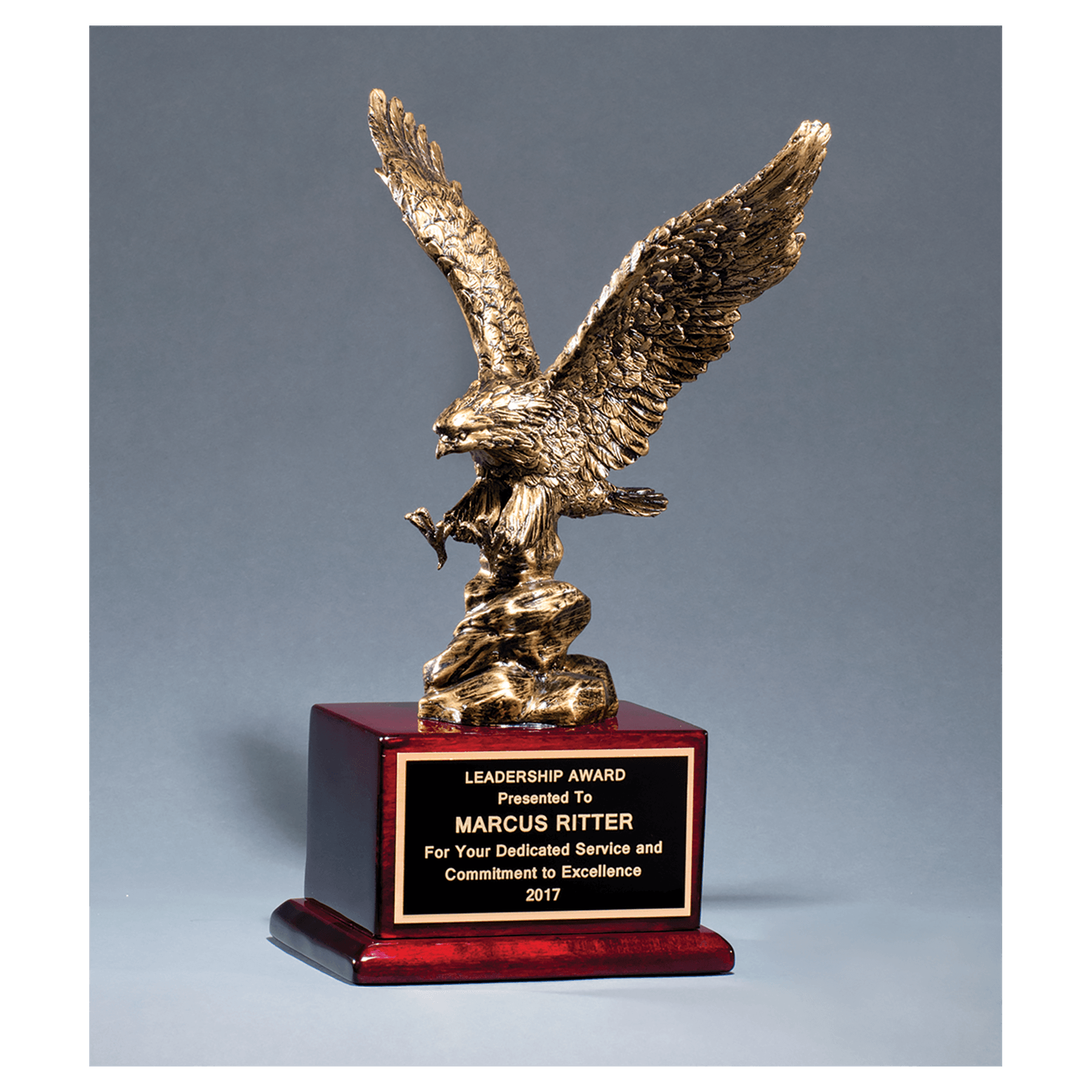 Antique bronze finished eagle resin casting on a rosewood piano finish base with a black brass engraving plate, 15 inches tall