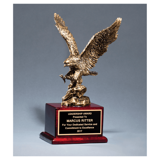 Antique bronze finished eagle resin casting on a rosewood piano finish base with a black brass engraving plate, 15 inches tall