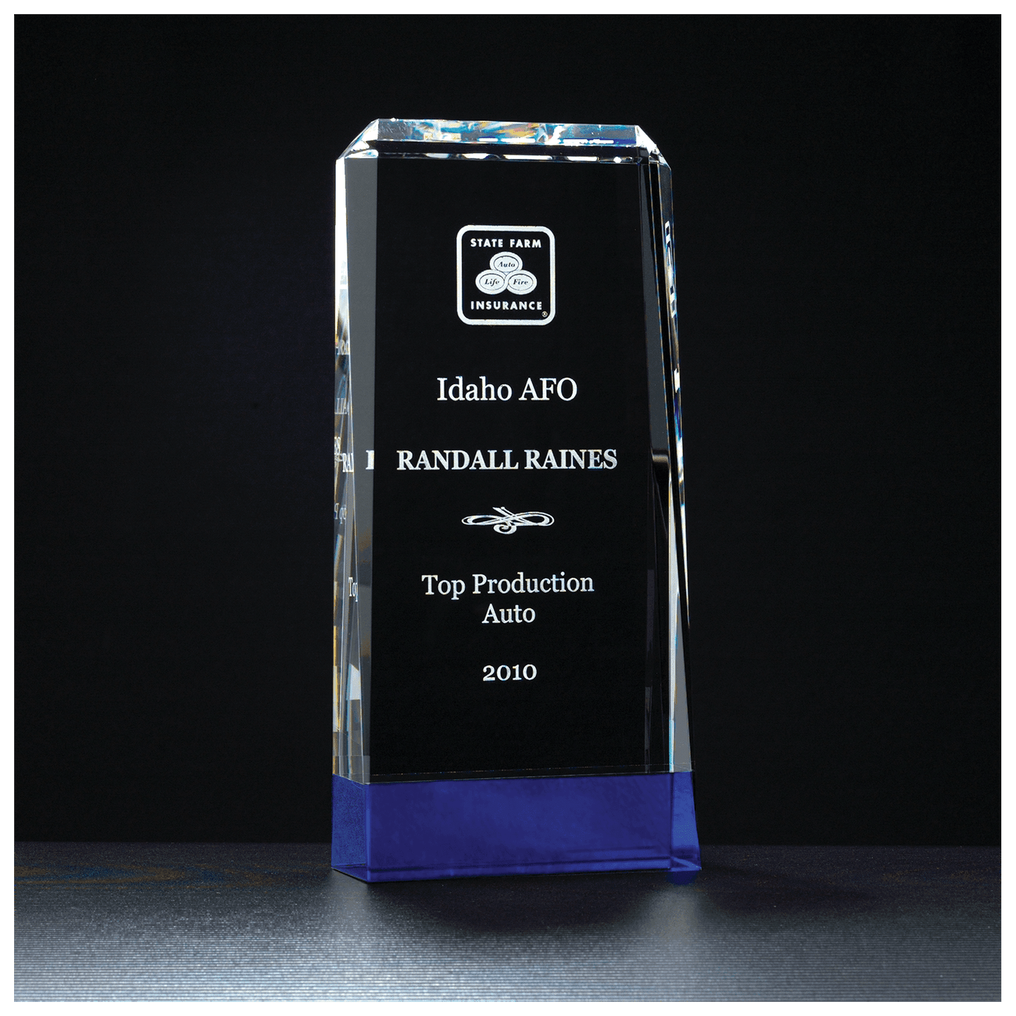 Crystal award with State Farm Insurance logo and engraved text on a black background