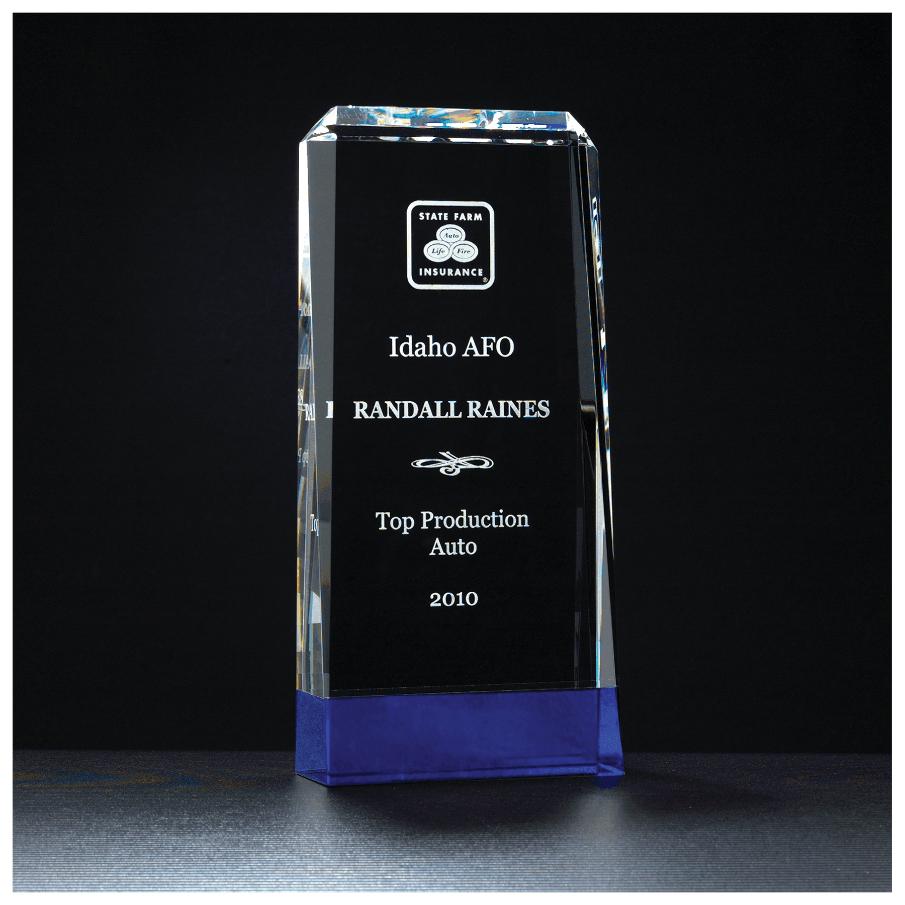 Crystal award with State Farm Insurance logo and engraved text on a black background