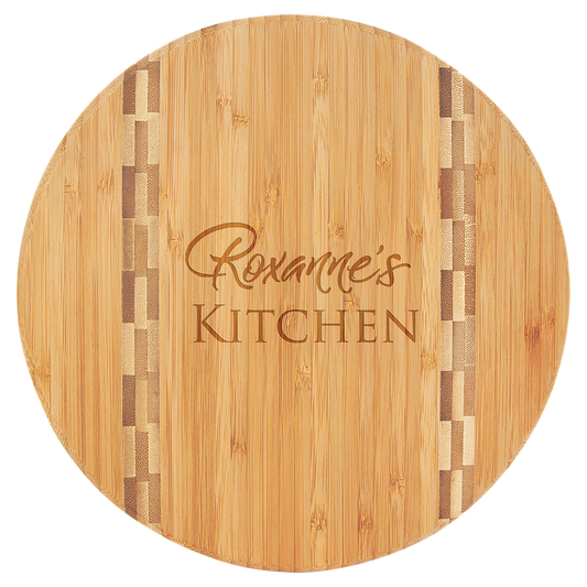 Round wooden cutting board with 'Roxanne's Kitchen' engraving on a clear background