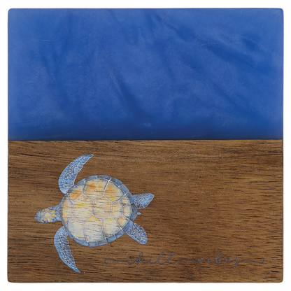 Engraved acacia and blue pearl resin square coaster with a drink