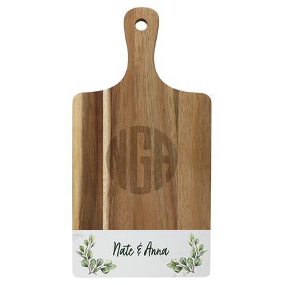 Engraved acacia and white marble paddle board styled with food