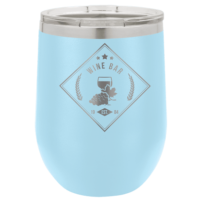 Light blue wine tumbler with 'Wine Bar' engraving on a green background