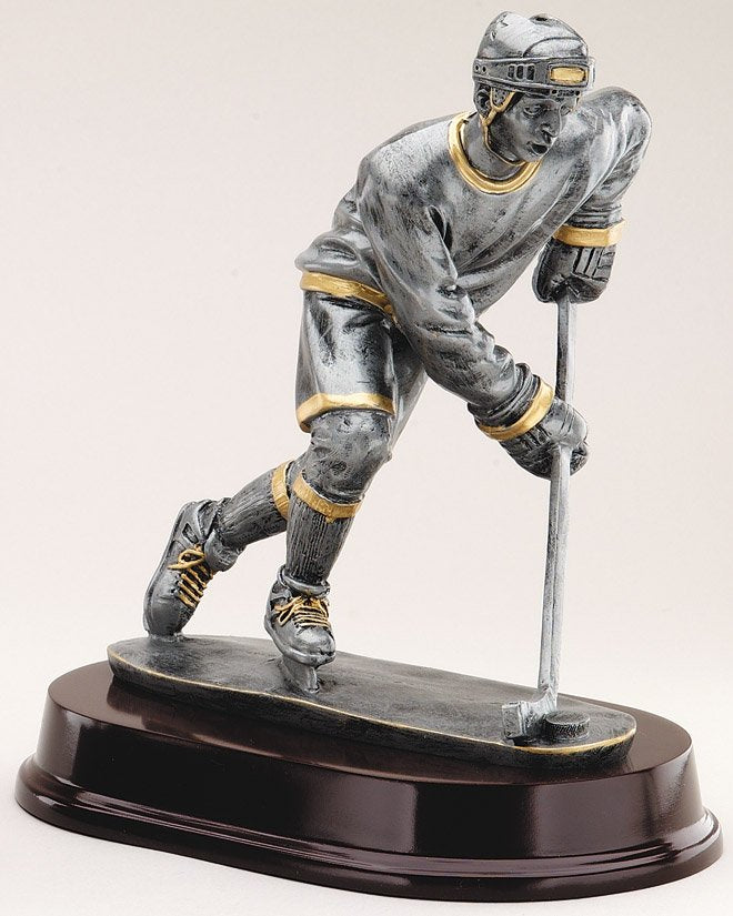 Pewter male hockey forward trophy with gold trim on oval base