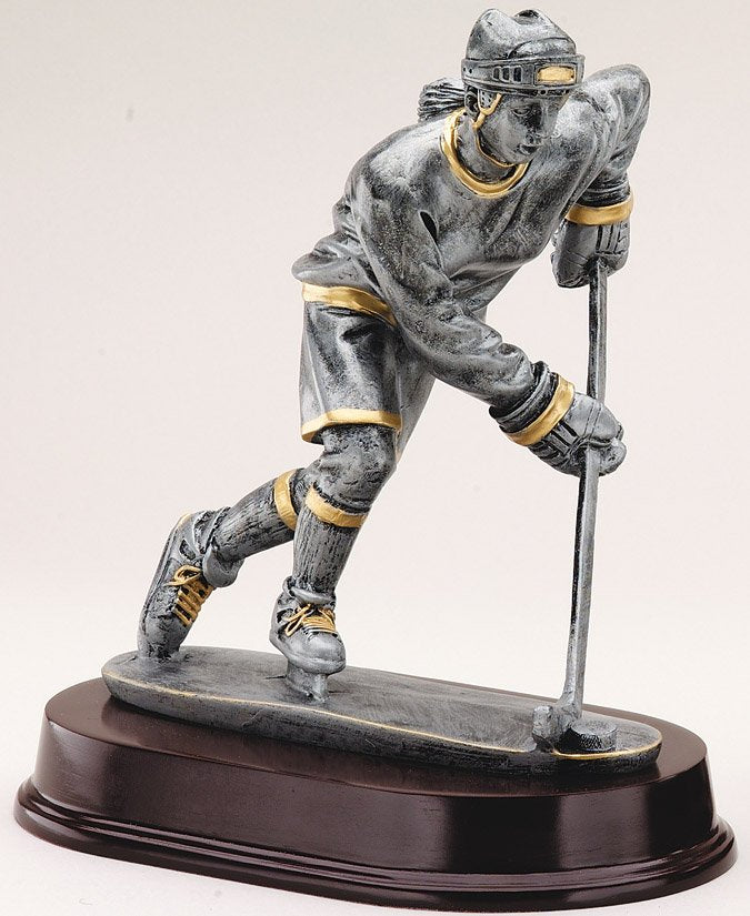 Pewter female hockey forward trophy with gold trim on oval base
