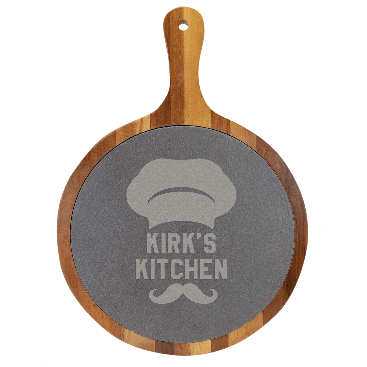 Round wooden cutting board with slate surface and 'Kirk's Kitchen' engraving on a transparent background