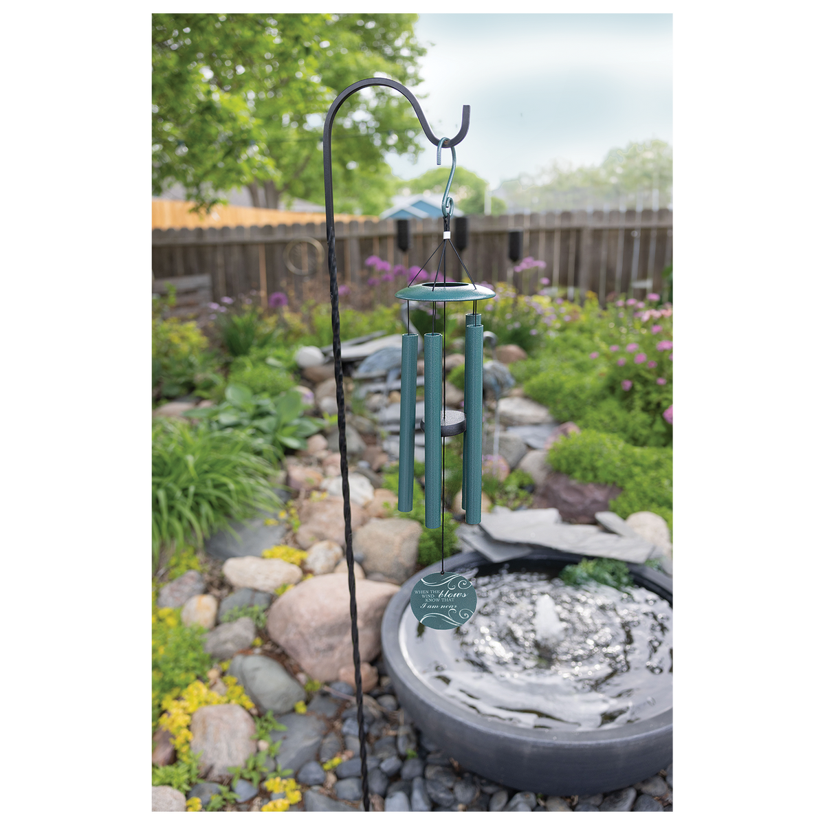 Engraved dark peacock green wind chime hanging outdoors