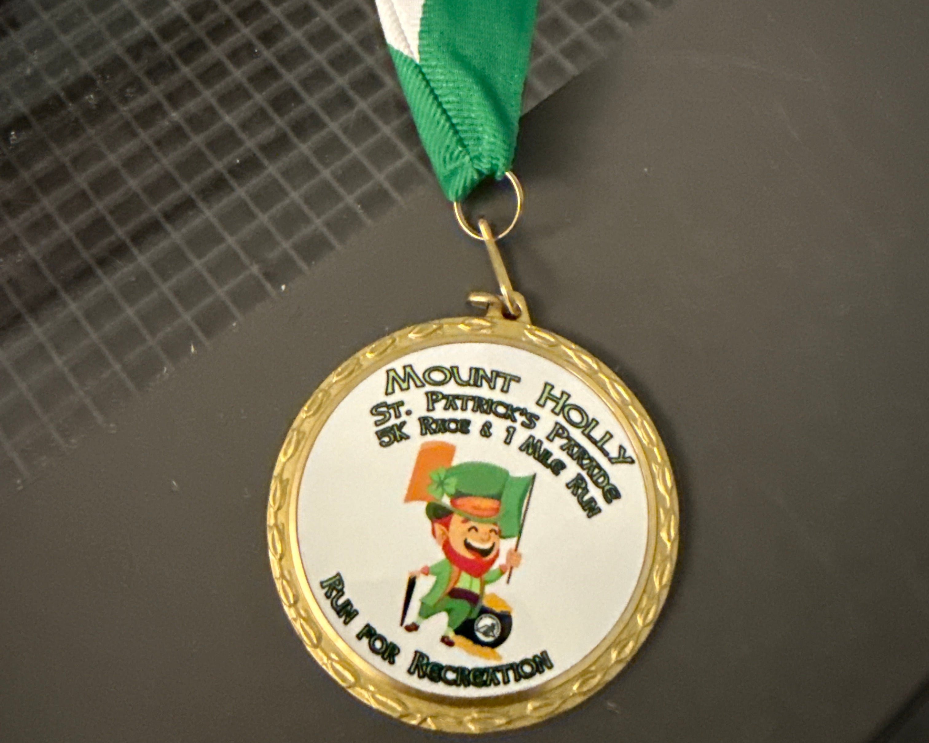 Medal with a green ribbon on a colored print surface