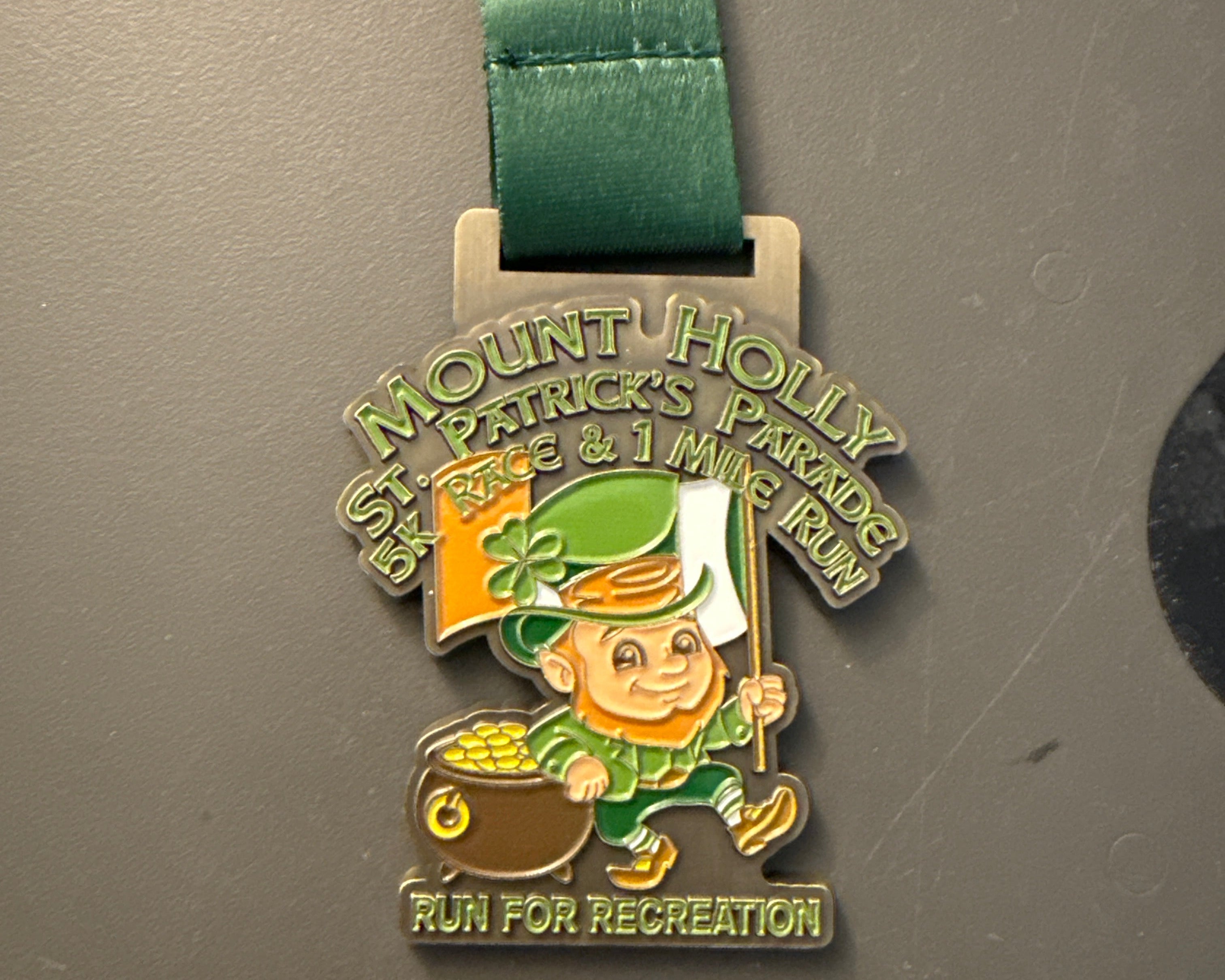 Medal with a green ribbon on a gray surface